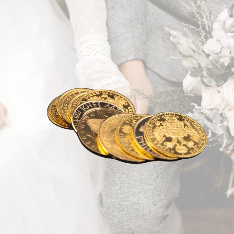 Ein Paar goldene Münzen wird von einer Hand mit einer Braut im Hintergrund gehalten.